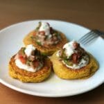 Bezglutenowe placki z cukinii z salsą i jogurtem na ceramicznym talerzu