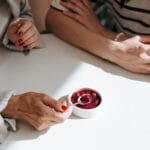 Dwie kobiety w eleganckich stylizacjach dzielą się jednym deserem