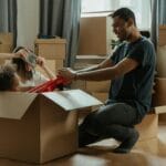 Rodzina bawi się przy rozpakowywaniu kartonów w nowym mieszkaniu
