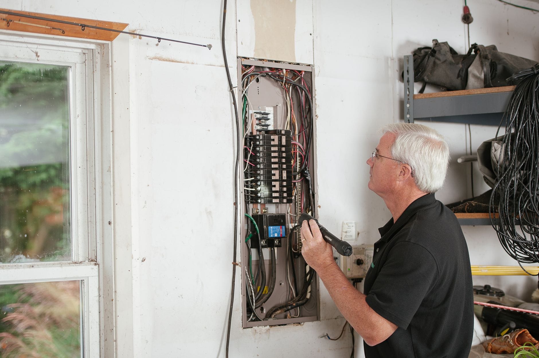 Elektryk sprawdza domową rozdzielnicę elektryczną w mieszkaniu