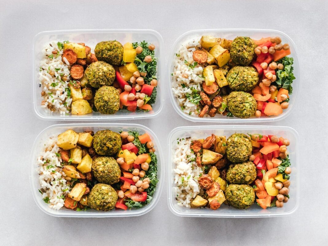 Kolorowe pojemniki z falafelem, ciecierzycą, ryżem i warzywami na meal prep