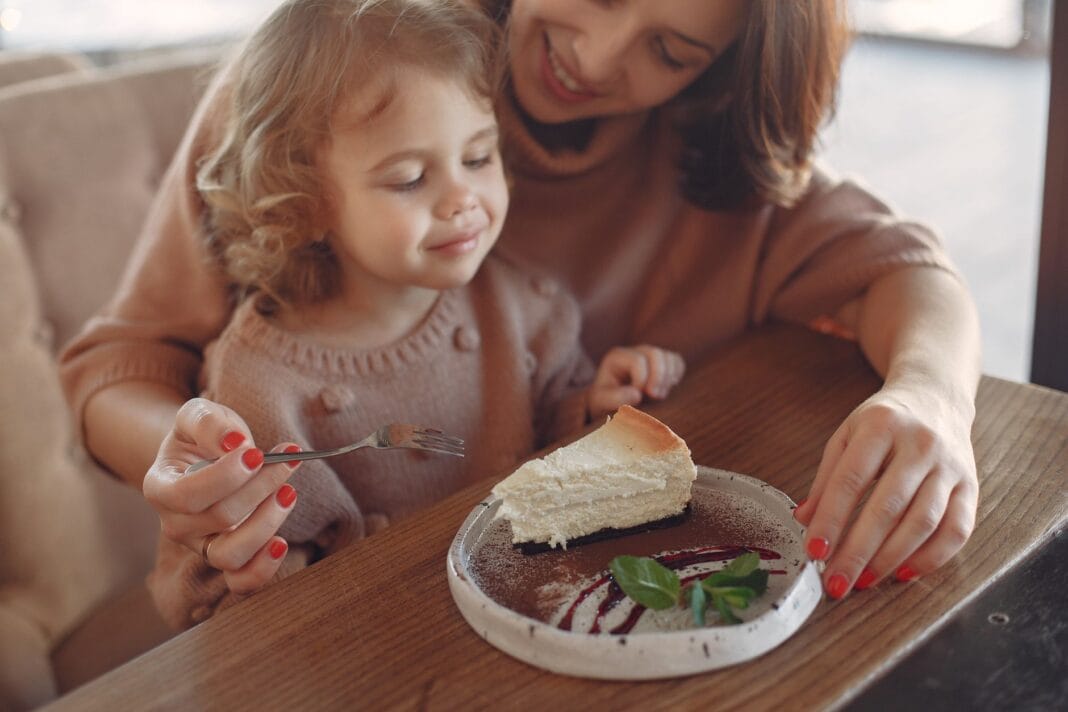 Mama i córka jedzą ciasto razem w kawiarni Mama i córka jedzą ciasto razem w kawiarni