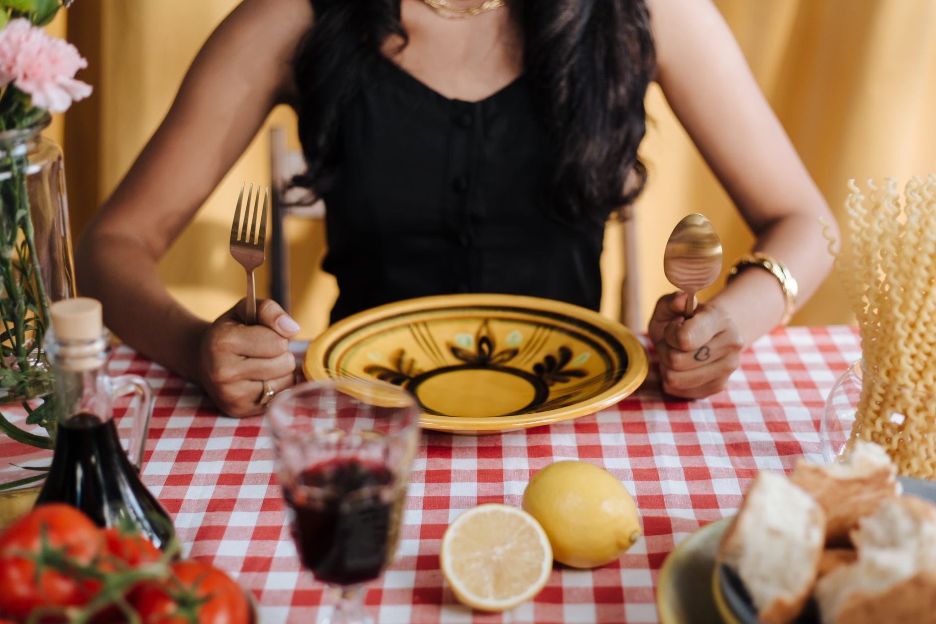 Kobieta przy stole z makaronem, winem i cytryną we włoskiej restauracji